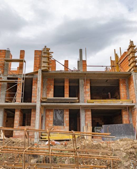 the outdoor construction site with unfinished orange building under a cloudy sky - residential complex